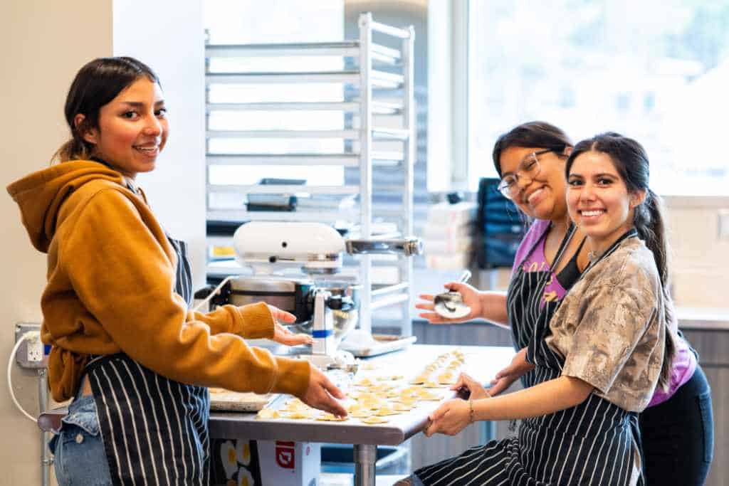 students cooking pasta in class